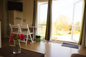 eine Vase mit Blumen auf einem Tisch in einem Zimmer mit Fenster in der Unterkunft Casa Floravista in Bombarral