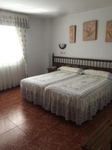 a bedroom with a bed in a room with a window at HOTEL O NOSO BAR in Cambados