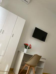 a white desk with a chair and a tv on a wall at Filippo Accomodation in Tropea