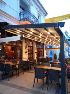 an outdoor patio with tables and chairs and a restaurant at Citalna Rooms in Bitola