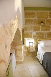 una camera da letto con un muro in pietra e un letto di Minuetto 54 a Ostuni