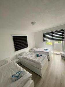 a bedroom with three beds and a window at House Enio in Bihać