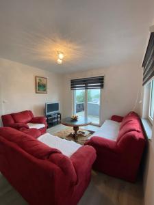 a living room with two red couches and a table at House Enio in Bihać