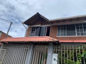 uma casa de tijolos com um telhado vermelho em MY HOUSE IN MACAS, SUITE AMOBLADA em Macas