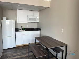 a kitchen with a wooden table and a white refrigerator at Simple Life Motel in Ocean City