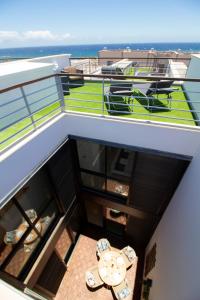 Un balcón con mesa y vista al mar. en MEDANO4YOU Lucias Rooftop Holiday Home, en El Médano