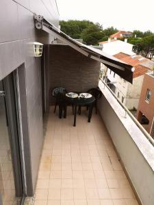 patio con mesa y sillas en el balcón en Apartamento Fração AX, en Esposende