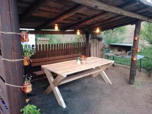 drewniany stół piknikowy pod drewnianą pergolą w obiekcie Zacisze w Supraślu