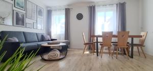 sala de estar con sofá, mesa y sillas en Apartment Traube - Stelvio, en Stelvio