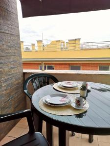un tavolo con due piatti e tazze su un balcone di Apartamento Fração AX a Esposende