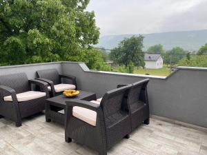 a balcony with three chairs and a table with fruit on it at House Enio in Bihać