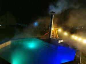 una piscina por la noche con humo saliendo de ella en Moldovița Residence, en Moldoviţa