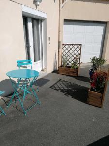 une table et des chaises devant un garage dans l'établissement Le repos chavagnais, à Chavagnes-en-Paillers