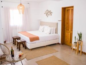 a bedroom with a white bed and a table and a room at My Pod House in Esquel
