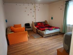 a bedroom with a bed and a couch and a chair at Viestura apartamenti in Daugavpils