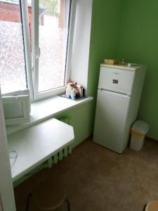 a kitchen with a white refrigerator and a window at Viestura apartamenti in Daugavpils