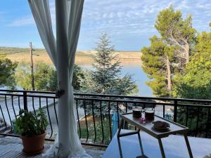 a balcony with a table and a view of a lake at Beach House Valerija in Rovanjska