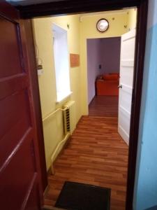 a hallway with a door and a clock on the wall at Viestura apartamenti in Daugavpils