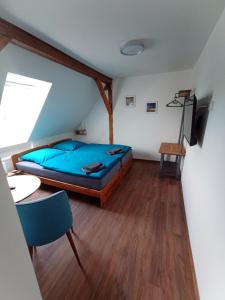 a bedroom with a bed and a table and a chair at Pension Zur Sülte in Sülte