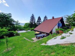 a building with a picnic table and a bench at Lake View Holiday Home in Cerknica