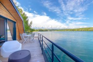 een terras met een tafel en stoelen op het water bij Maison flottante - Houseboat - Baurech Insolite in Baurech