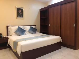 1 dormitorio con 1 cama grande y armario de madera en A1 Hotel, en Phnom Penh