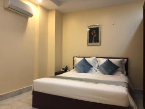 1 dormitorio con 1 cama grande con almohadas azules en A1 Hotel, en Phnom Penh