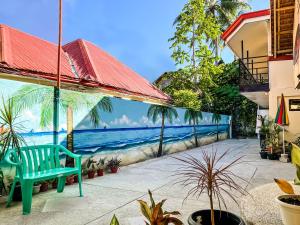 uma cadeira azul num pátio com um mural da praia em White Shamrock Beach Hotel em Boracay