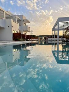 - une piscine d'eau bleue en face d'un bâtiment dans l'établissement Κimiro Hotel Tsilivi, à Planos