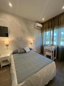 a bedroom with a large white bed and a desk at Villa D Erna Marina di Pietrasanta in Marina di Pietrasanta