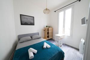 ein Schlafzimmer mit einem Bett, auf dem zwei Handtücher liegen in der Unterkunft AppartUnique - Chez Layette in Vichy