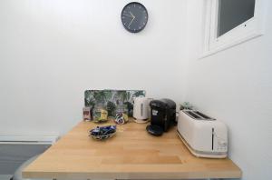 eine Küchentheke mit einer Uhr an der Wand in der Unterkunft AppartUnique - Chez Layette in Vichy