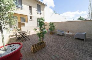 eine Terrasse mit Stühlen und Tischen und ein Gebäude in der Unterkunft AppartUnique - Chez Layette in Vichy