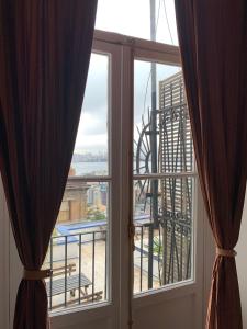 d'une fenêtre avec des rideaux et une vue sur la ville. dans l'établissement A Historical Galata Flat w Bosphorus View, à Istanbul