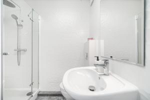 a white bathroom with a sink and a shower at Apartament 400 bulwary Stare Miasto Apartamenty No 1 in Szczecin +20 photos