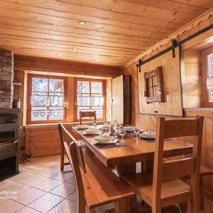 uma sala de jantar com uma mesa de madeira e cadeiras em La Centaurée em Bonneval-sur-Arc