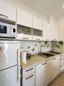 Una cocina blanca con fregadero y microondas. en Apartman Anka, en Dubrovnik
