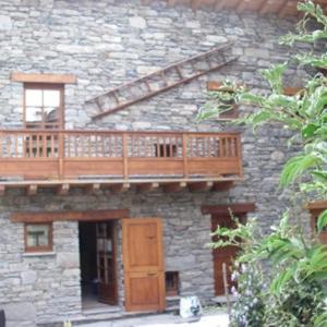 a deck on the side of a stone building at La Centaurée in Bonneval-sur-Arc