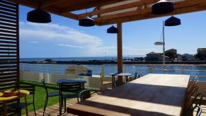 a table and chairs on a balcony with a view of the water at Mon P'tit Hôtel in Le Grau-dʼAgde