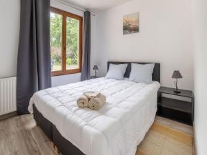 sypialnia z dużym białym łóżkiem z 2 ręcznikami w obiekcie Holiday Home with Roofed Swimming Pool w mieście Villeneuve-sur-Lot