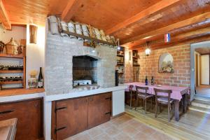a kitchen with a stone fireplace and a table at NEW! Holiday home Dalmazia in Vir