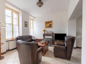 een woonkamer met lederen stoelen en een televisie bij Nice holiday home in Hambye with parking in Hambye