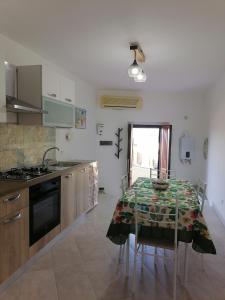 a kitchen with a table with chairs and a stove at A casa di Ro` in Agrigento