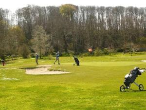 a couple of people and a dog on a golf course at Holiday Home in Plouarzel near Sandy Beach in Plouarzel