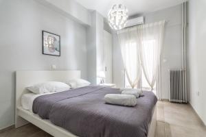 a white bedroom with a large bed with two pillows on it at Sailor's Friend in Piraeus