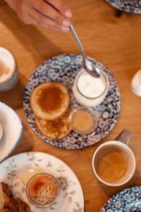 einen Tisch mit einem Teller Pfannkuchen und Tassen Kaffee in der Unterkunft Boutique Hotel Villa Monika in Westerland