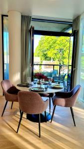 a dining room with a table and chairs and a window at Park Premium Apartments in Birštonas