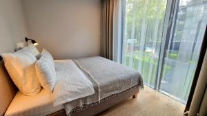 a bedroom with a bed and a large window at Park Premium Apartments in Birštonas