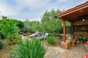 einen Garten mit einer Terrasse mit Stühlen und einem Pavillon in der Unterkunft NEW! Holiday home Dalmazia in Vir