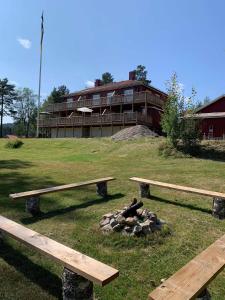 two picnic tables and a fire pit in front of a building at Järvsö Sport Resort- Lgh B in Järvsö